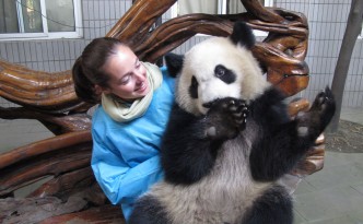 Annie with a panda on the lap at the panda reserve in Chengdu China