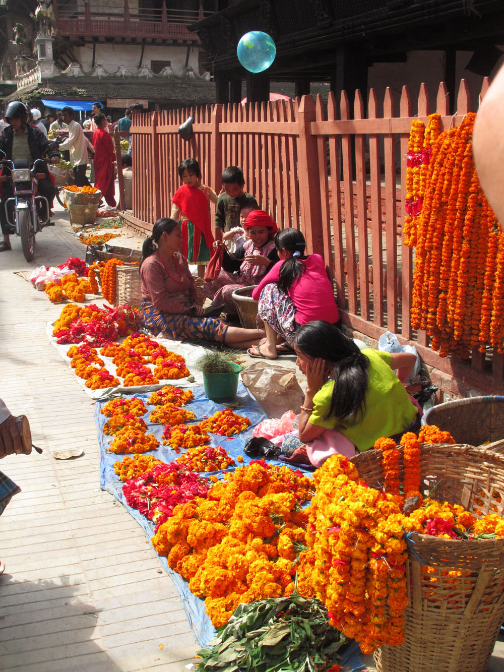 women create long strands of Marigolds, Durbar Square, Kathamandu Nepal