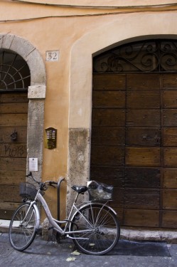Bicycle leaning on apartment building | Rome, Italy